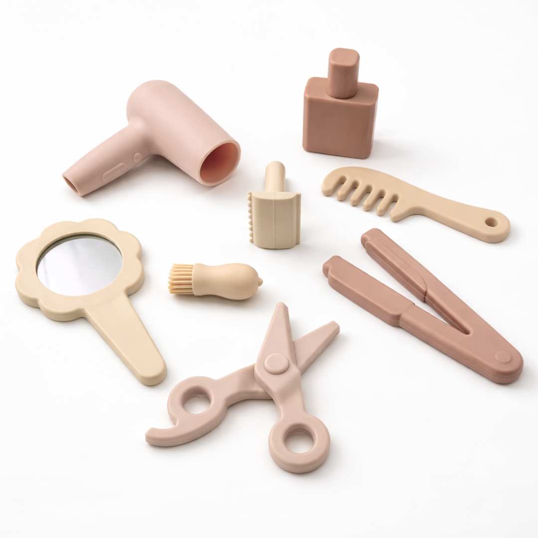 Silicone Hair Stylist Play Set for toddlers including pretend hair dryer, comb, scissors, mirror, straightener, brush, roller and styling bottle.